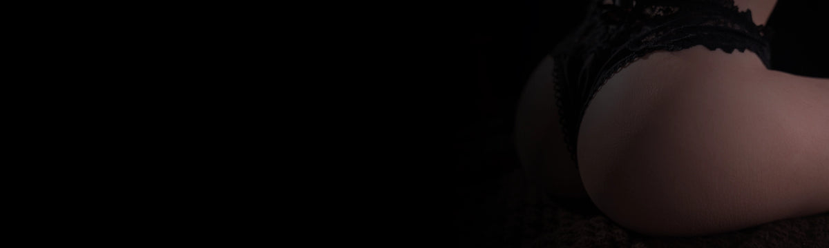 Poce’s sculpted butt torso styled with black lingerie against a dark backdrop.