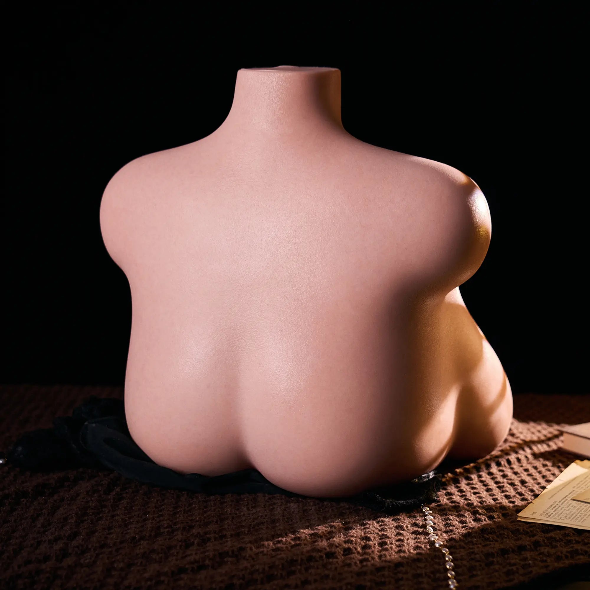 Image of MRLDOLL Tess torso on a desk, side-back view highlighting natural curves and glossy, lifelike skin texture